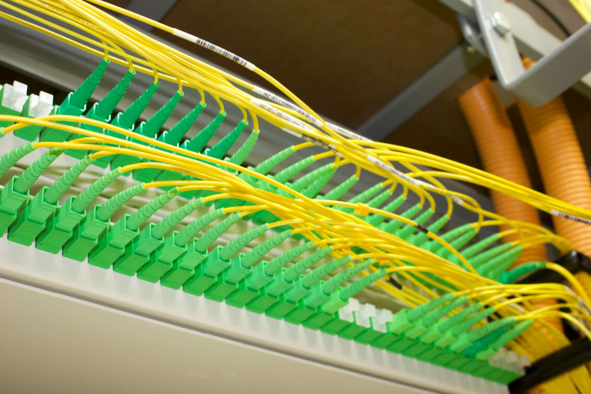 Glasvezelverdeler met groene connectoren en gele glasvezelkabels